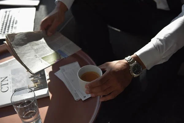 a cinematic photo of a business man with a cup of coffee and newspaper