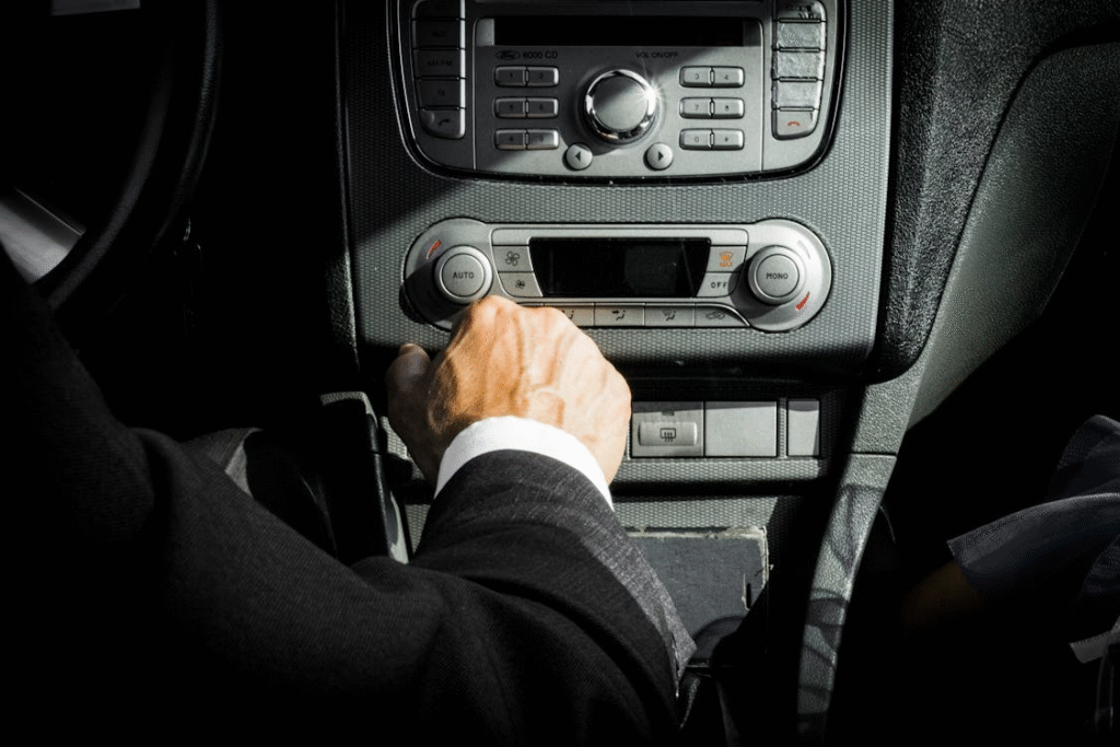 photo showing a person's hand pressing on some button in the car