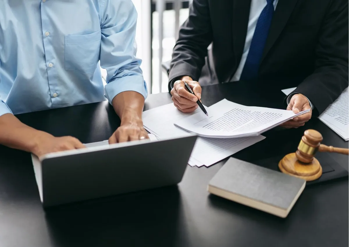 Employment lawyer reviewing payroll documents and an employment contract with a worker to explain whether an employer can reduce your pay.