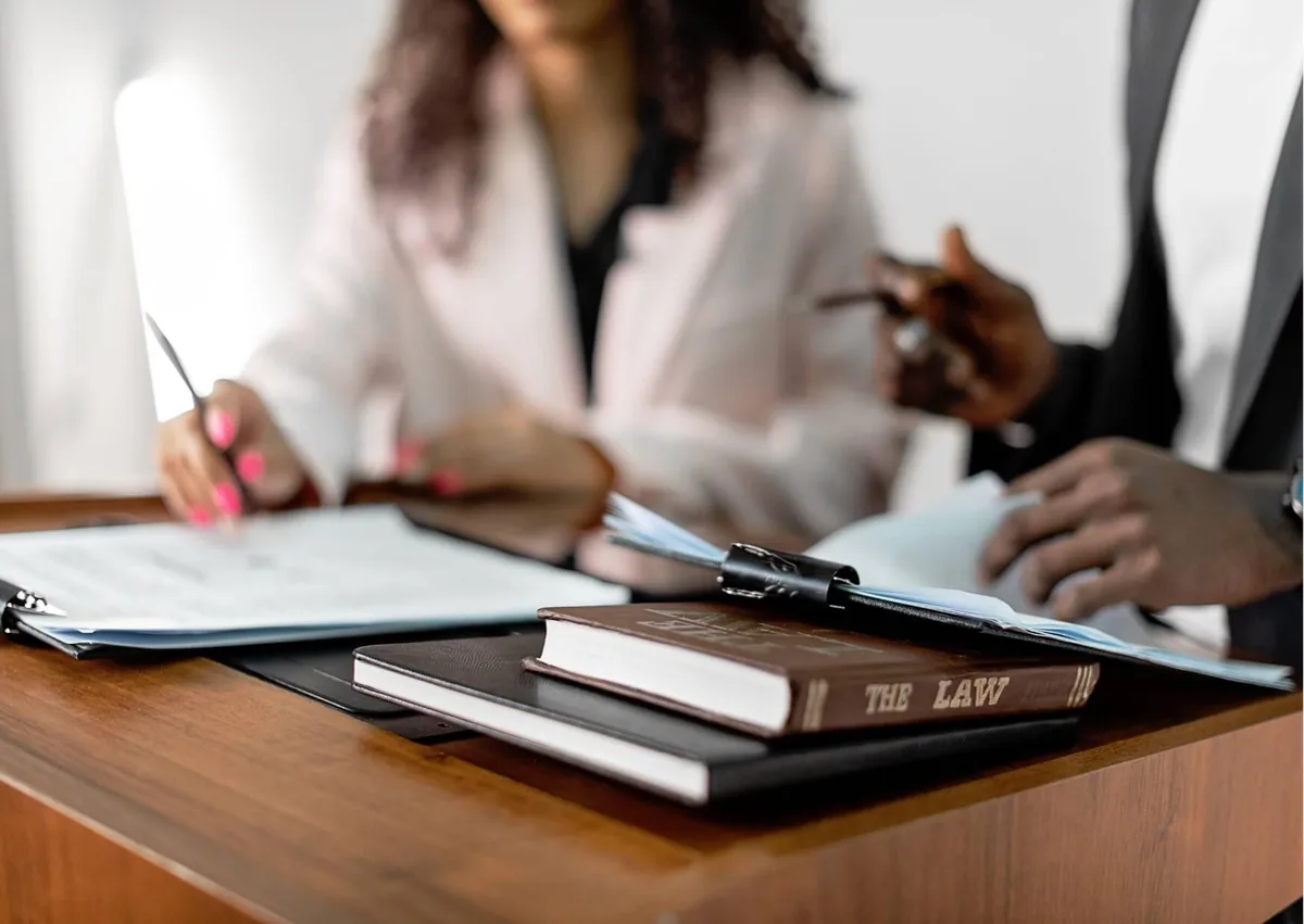Employment lawyer reviewing work schedules and payroll documents with a client to discuss reporting time pay and potential wage violations.