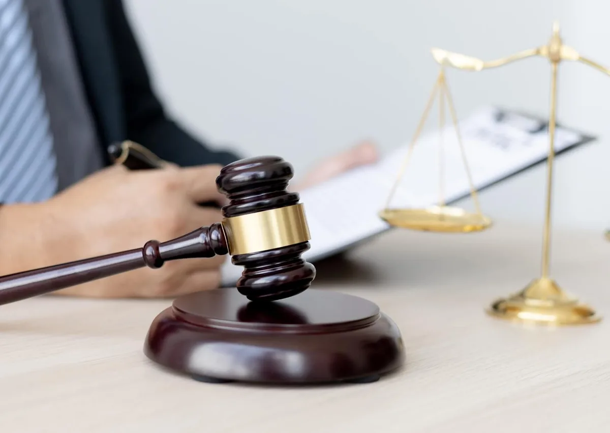 Employment law consultation with legal documents, a judge’s gavel, and scales of justice, representing legal action related to workplace harassment.