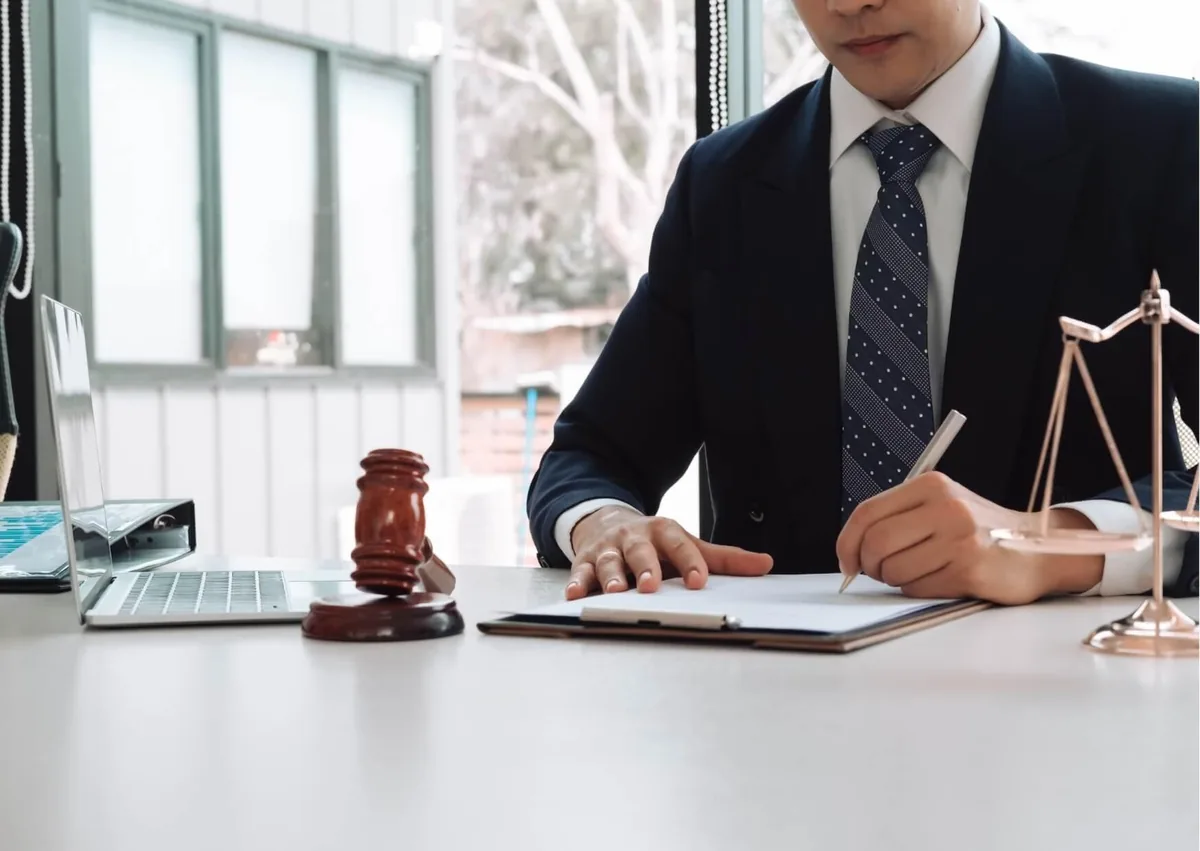 Employment lawyer reviewing workplace documents beside a judge’s gavel and scales of justice for an administrative exemption wage classification case.